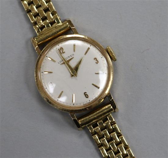 A ladys 9ct Longines manual wind wrist watch, on an 18ct gold bracelet.